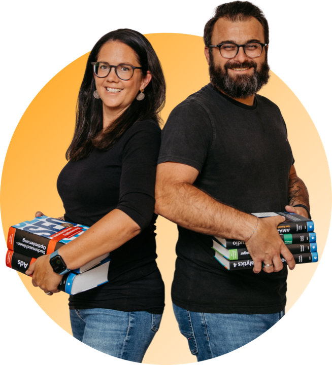 Romana and Florian Hieß back to back, each carrying a stack of technical books