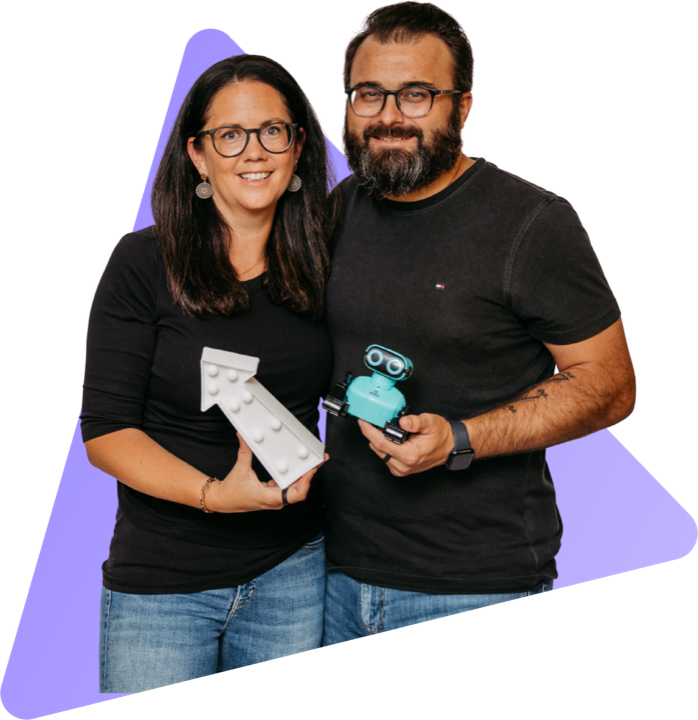 Romana Hieß holding an illuminated arrow pointing upward, Florian Hieß holding a small robot