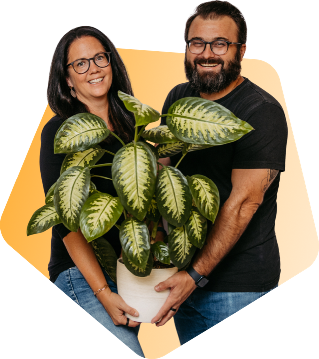 Romana and Florian Hieß carrying a large houseplant together