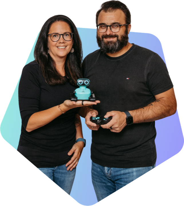 Romana Hieß holding a small robot in her palm, Florian Hieß holding its remote control
