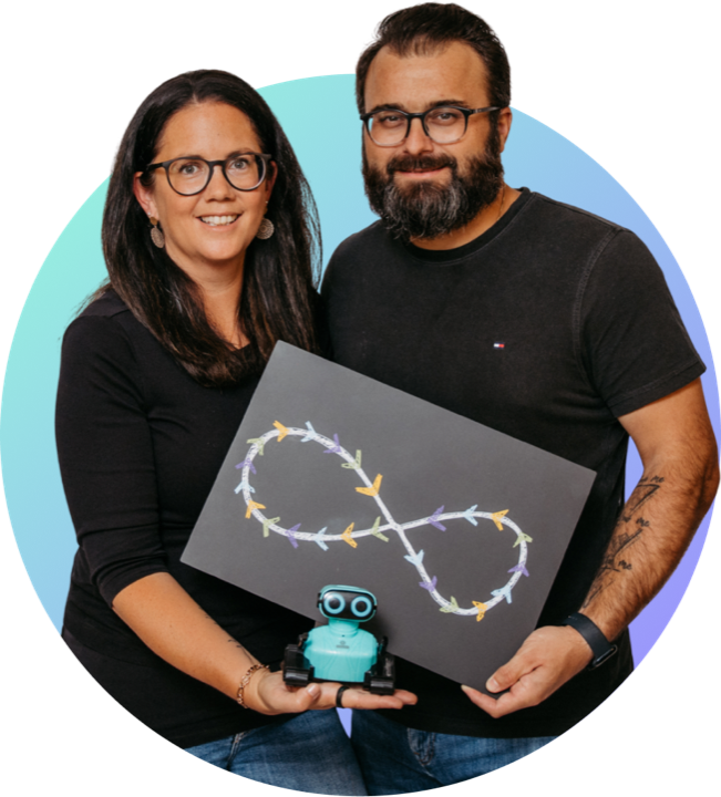 Romana and Florian Hieß holding a chalkboard with a drawn infinity loop, a small robot in front