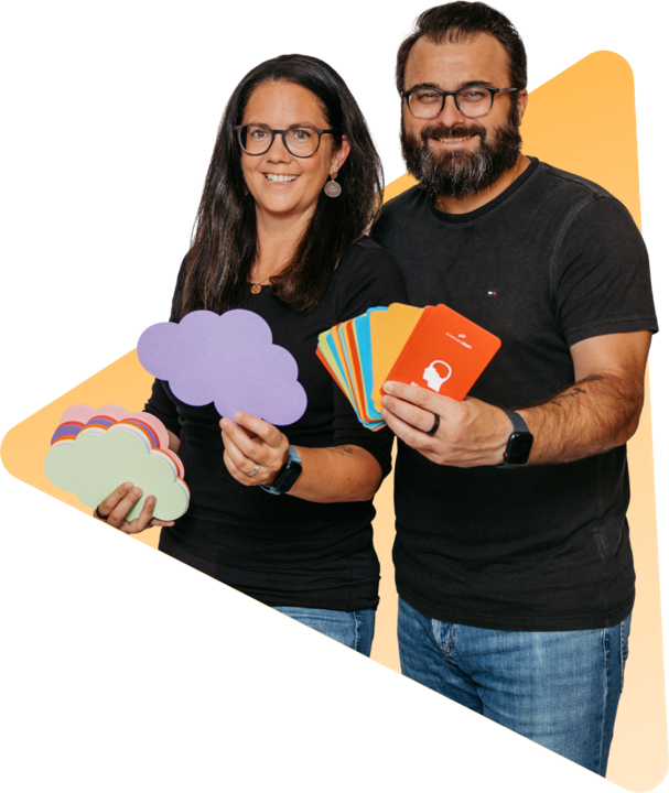 Romana Hieß holding cardboard speech bubbles, Florian Hieß fanning out coloured cards